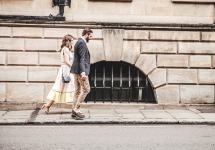 Man In Black Formal Suit Jacket Walking Together With Woman In White Sleeveless Dress photo