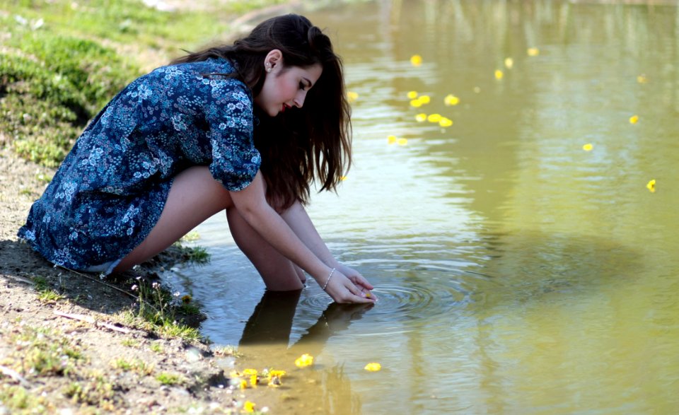 Woman Soaking Her Feet On Body Of Water During Daytime