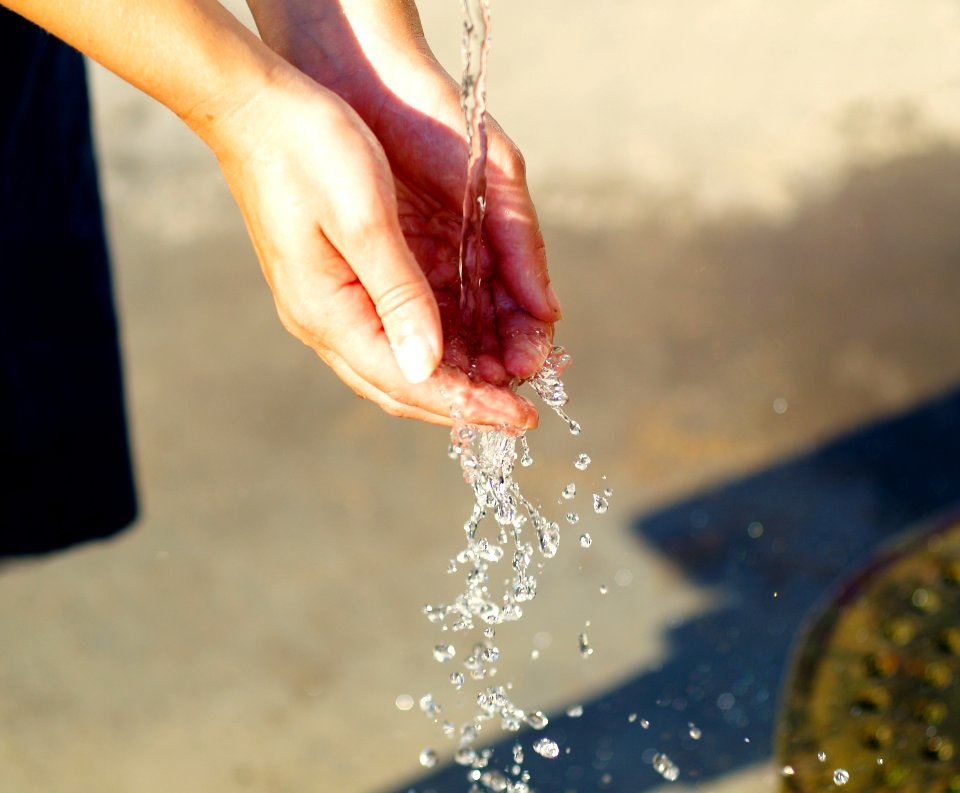 Water Pouring On Persons Hand