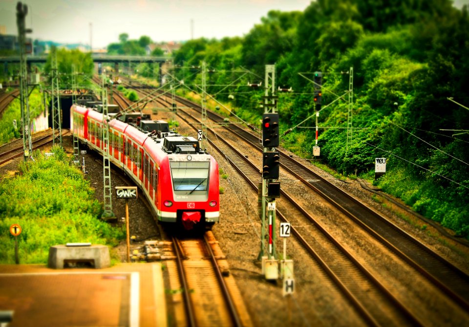 Red Train On Black Train Tracks Near Trees At Daytime