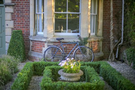 Grey Mountain Bike Leaning On Brown Wall Brick In Garden photo