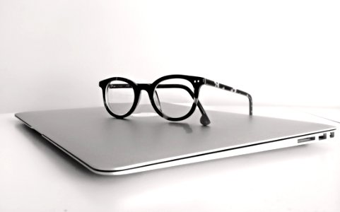 Black Frame Eyeglasses On Silver Macbook Air