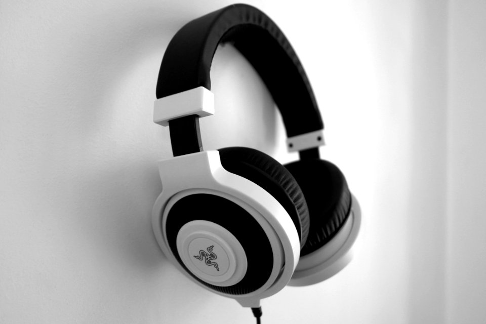 Black And White Razer Gaming Headset Hanging On White Painted Wall photo