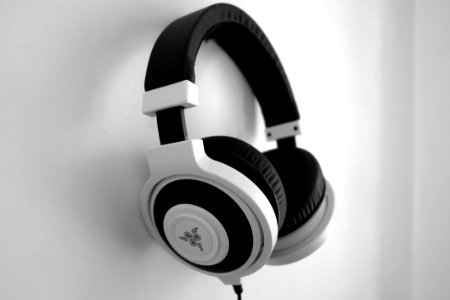 Black And White Razer Gaming Headset Hanging On White Painted Wall photo