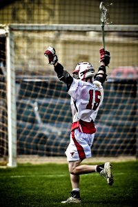 Man Holding Lacrosse Running Towards Goal photo