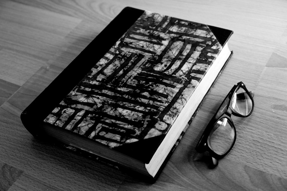 Grayscale Photo Of Eyeglasses Near Thickbound Book