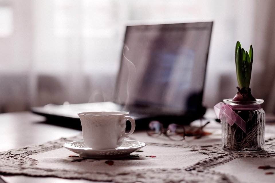 A Cup Of Coffee A Flower And A Laptop