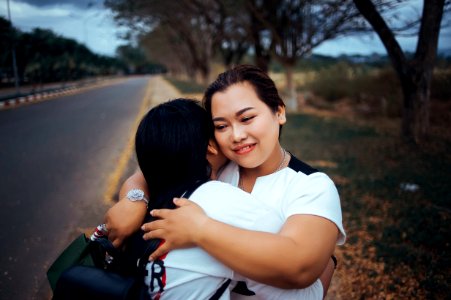 Two Women Hugging Each Other Standing On Pathway Of The Road