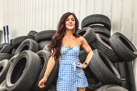 Woman Wearing Blue Flannel Dress Standing In Front Car Tires photo