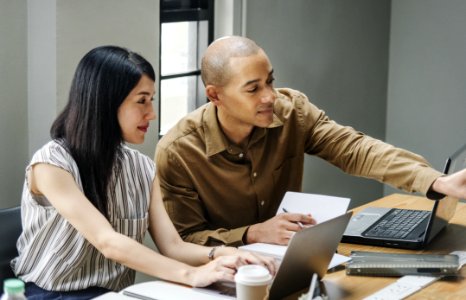 Man And Woman Looking At Laptop Computers