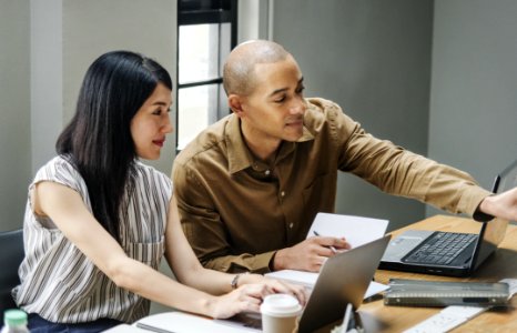 Man And Woman Looking At Laptop Computers photo