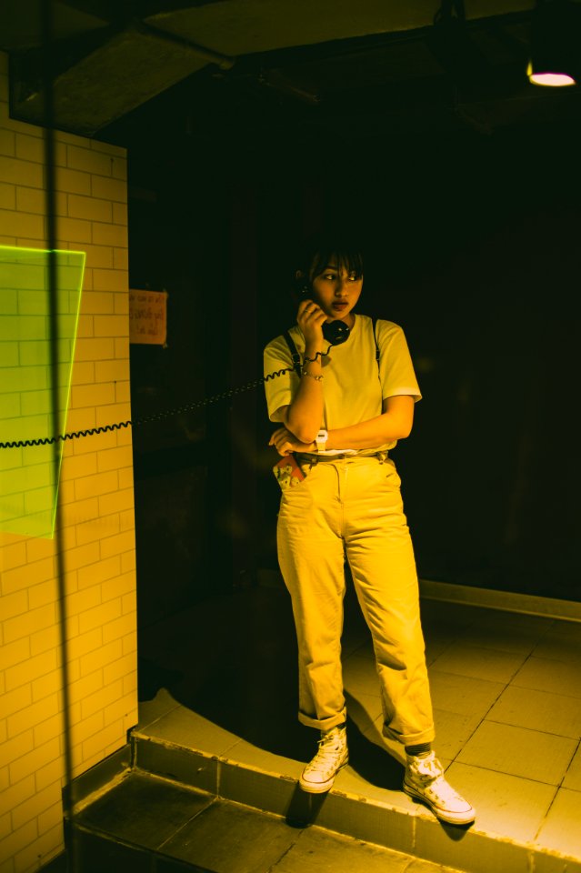 Photo Of Female Standing Using A Payphone