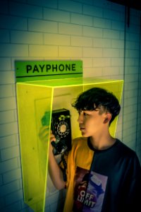 Boy Holding Payphone Receiver