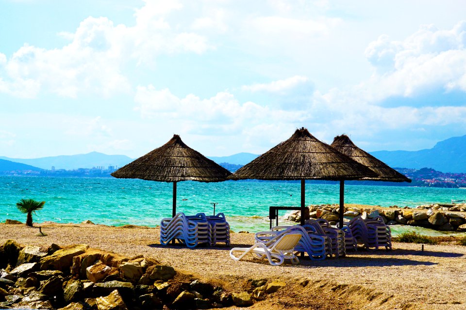 Three Brown Parasols On Seashore