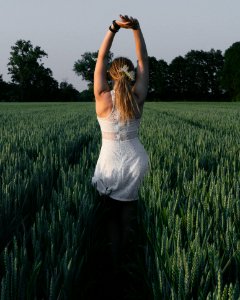 Woman Wearing White Lace Dress With Hands Raised Above Head photo