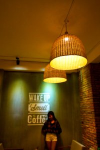 Woman Standing And Leaning Beside Wake Up Smell The Coffee Text Wall