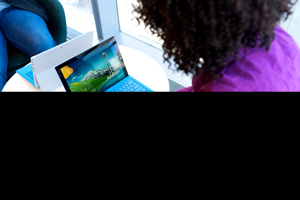 Person Using Blue Laptop Sitting Beside Table