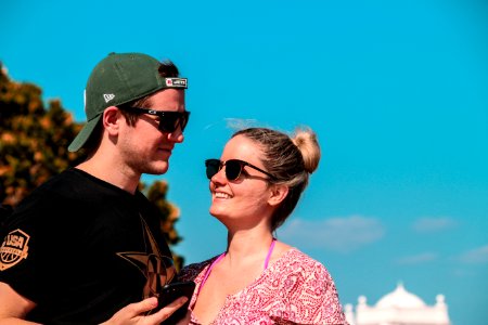 Selective Focus Photo Of Couple Stands Behind Green Tree At Daytime photo