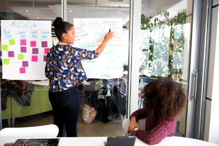 Two Women Having A Meeting Inside Glass-panel Office