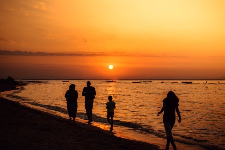 Silhouette Of People Walking On Seashore During Sunset photo