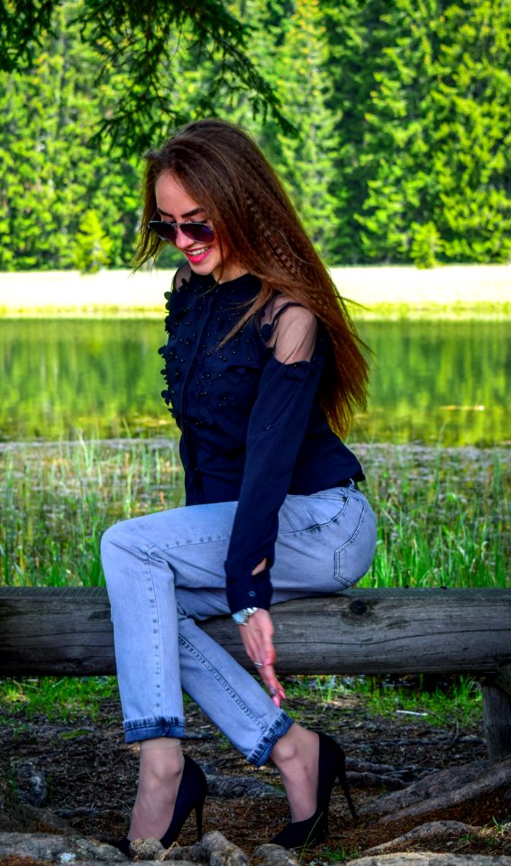 Woman Wearing Black Cold-shoulder Top And Blue Denim Jeans photo