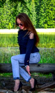 Woman Wearing Black Cold-shoulder Top And Blue Denim Jeans photo