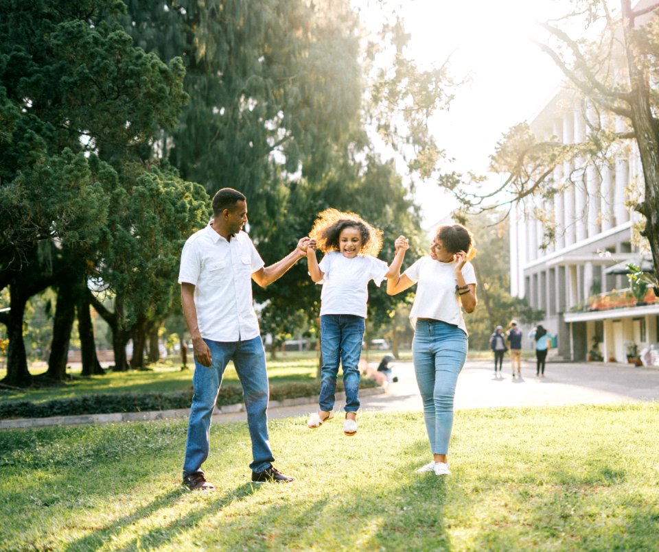 A Man And A Woman Assisting A Girl While Jumping