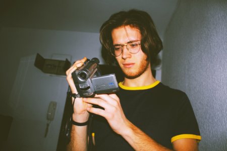 Man Wearing Black Shirt Holding Digital Camcorder photo
