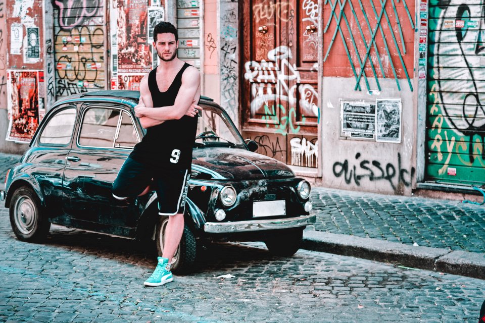 Man In Black Tank Top Standing Beside Black 3-door Hatchback