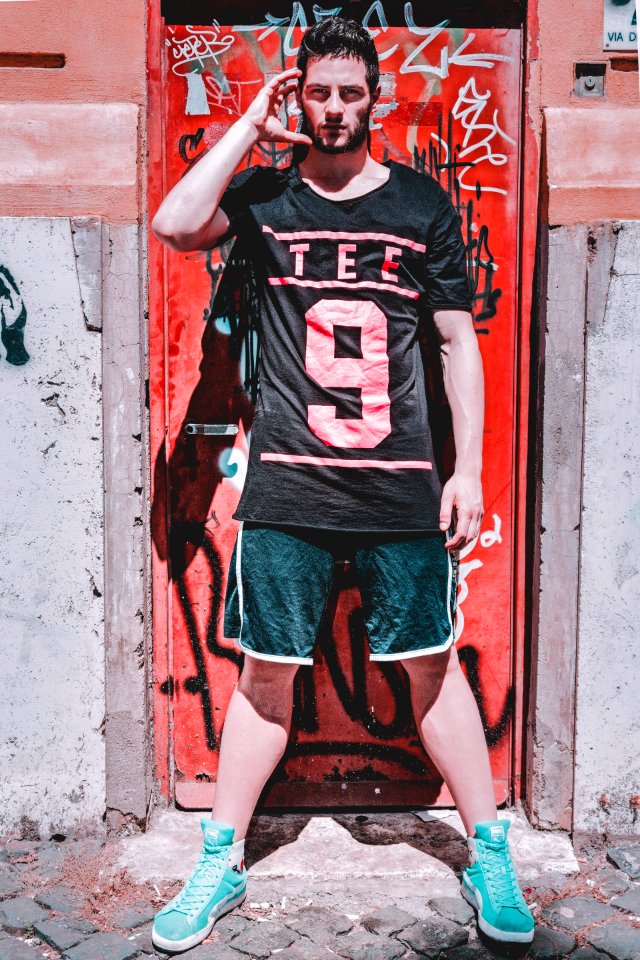 Man Wearing Black T-shirt Standing Near Red Metal Door photo