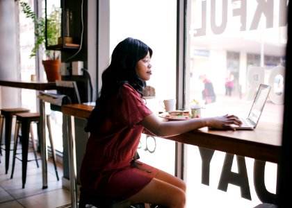 Woman In Red Dress Using Laptop On Table