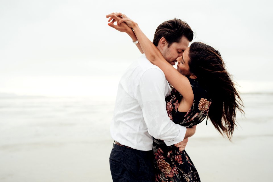 Man And Woman Hugging Each Other Near Body Of Water photo