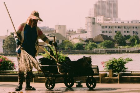 Person Holding Broom And Cart photo