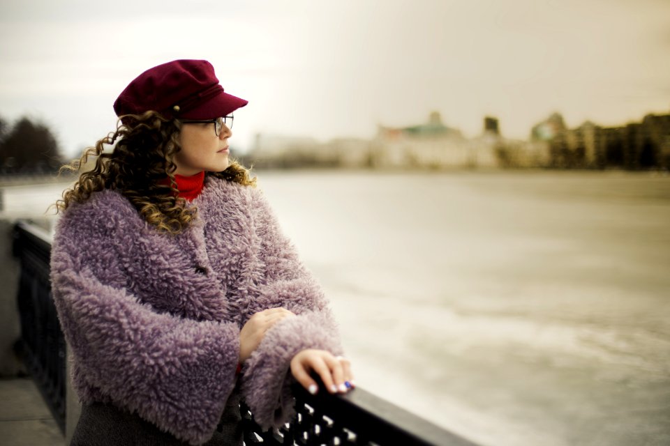 Woman Wearing Purple Fleece Coat Standing Beside Black Metal Fence Near Body Of Water