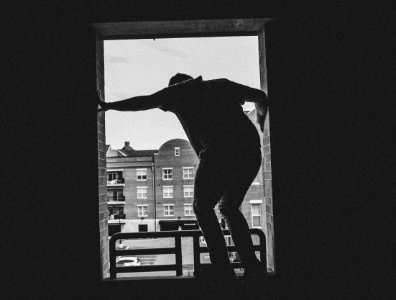Grayscale Photo Of Person Near Building
