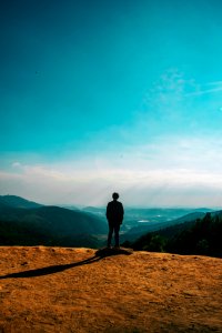 Silhouette Of Person Standing On Hill Under Clear Blue Sky photo