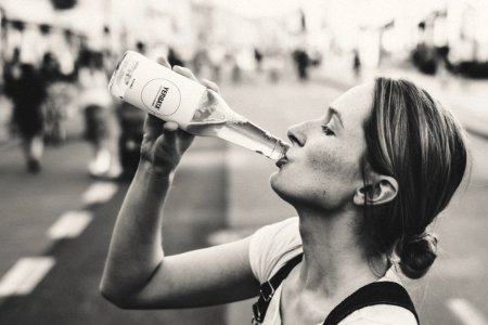 Woman Holding Glass Bottle In Grayscale Photo
