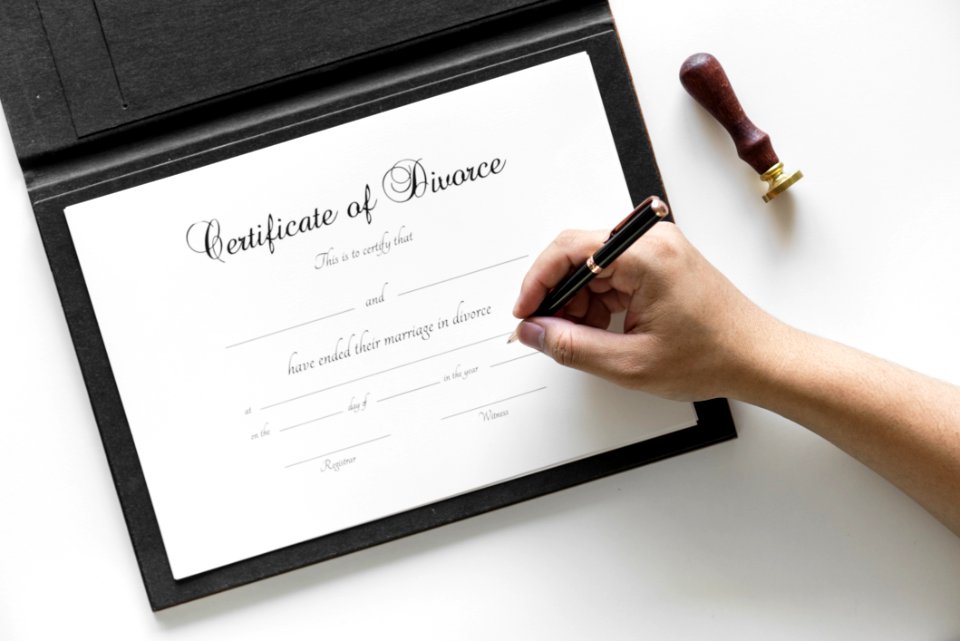 Person Holding Black Twist Pen Pointing On White Printer Paper