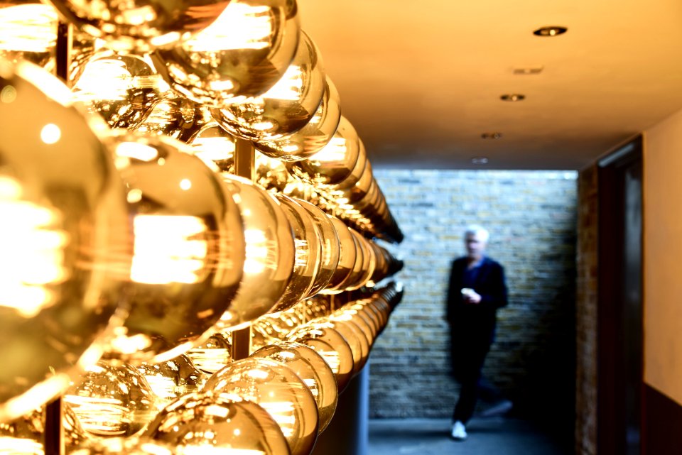 Man Passing Near Brown Brick Wall