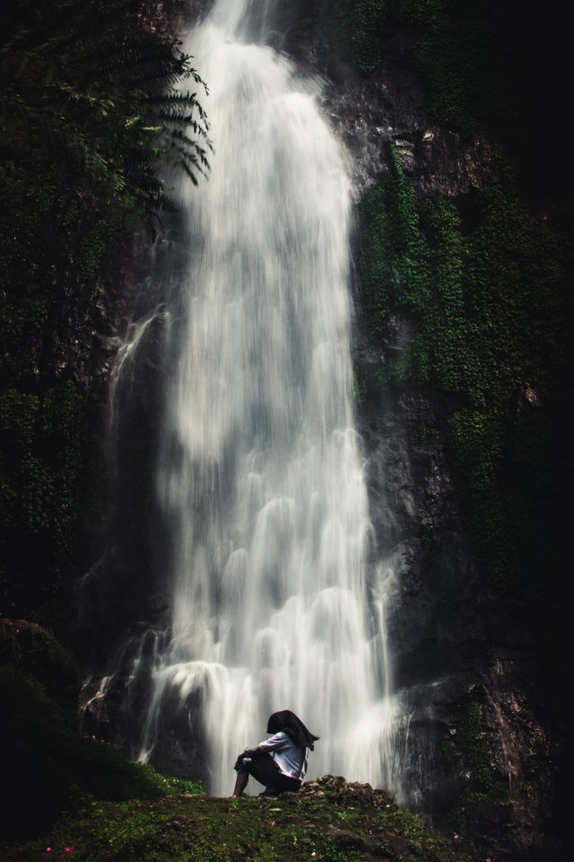 Photo Of Man Sitting Near Waterfalls