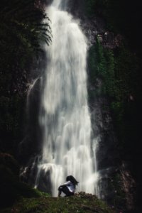 Photo Of Man Sitting Near Waterfalls photo