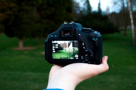 Shallow Focus Photography Of Black Dslr Camera On Persons Right Hand photo