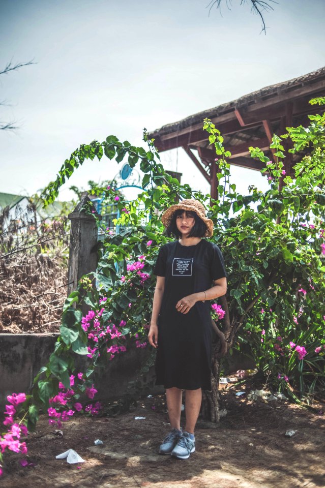 Woman Wearing Black Crew-neck Dress Standing Beside Pink Flowers