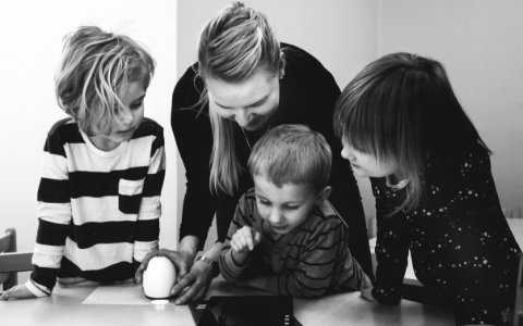 Grayscale Photo Of Mother And Three Children Playing photo