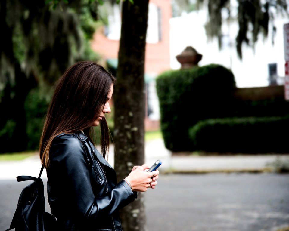 Woman In Black Leather Jacket Holding Smartphone photo