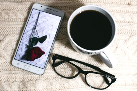 Phone Near Mug And Eyeglasses On Table photo