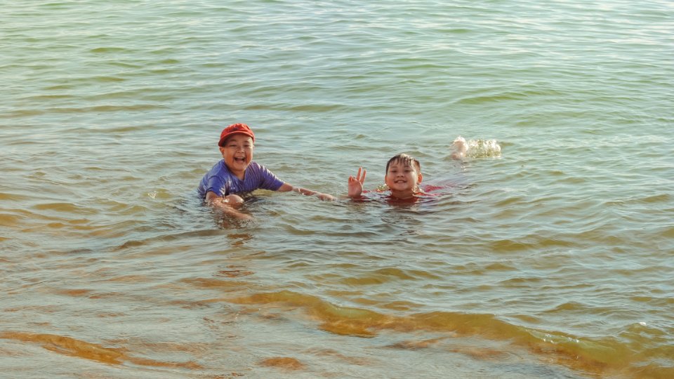 Two Boy On Brown Body Of Water