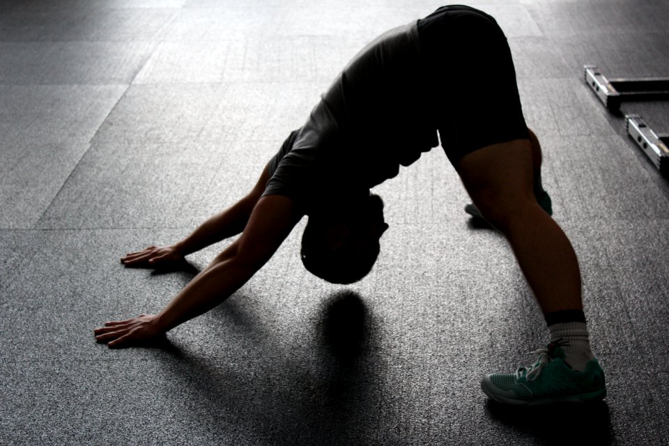 Man In Grey Shirt Doing Yoga On Gray Ceramic Tile Floor