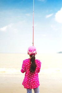 Woman In Pink Long-sleeved Shirt Holding Red Fishing Rod photo