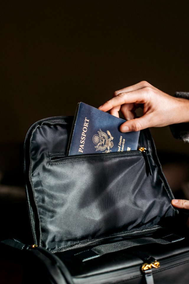 Person Putting A Passport On Bag photo